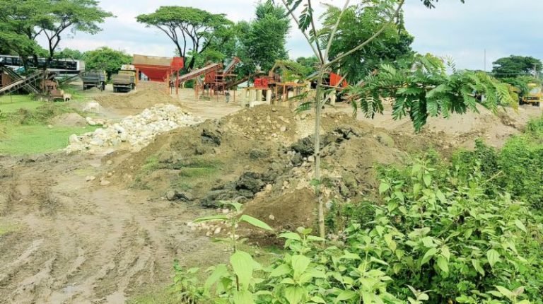 সড়কের দুই পাশের ক্রাশার মিলে মাটি-বালু দিয়ে ঢেকে রাখা সাদাপাথর